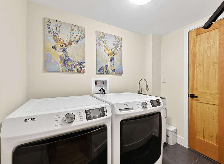 This laundry room features a pair of white Maytag washers and dryers, perfect for handling large loads.