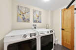 This laundry room features a pair of white Maytag washers and dryers, perfect for handling large loads.
