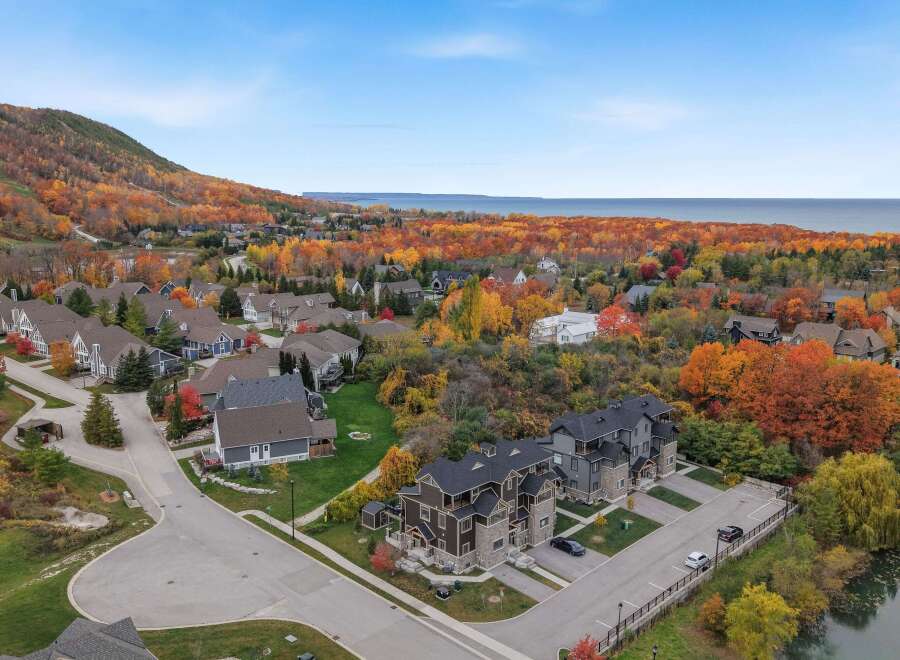 Experience the beauty of autumn from this stunning aerial view, showcasing a charming neighborhood nestled amidst vibrant fall foliage.