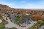 Experience the beauty of autumn from this stunning aerial view, showcasing a charming neighborhood nestled amidst vibrant fall foliage.