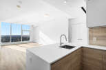 Experience modern living in this stunning apartment featuring a sleek kitchen with a waterfall island and contemporary wood cabinetry.