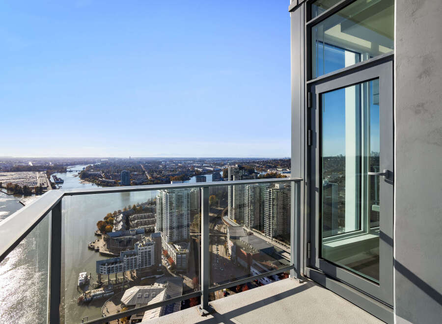 Experience breathtaking panoramic views from this high-rise balcony, offering a stunning vista of the city skyline, river, and distant mountains.