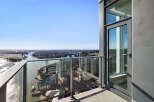 Experience breathtaking panoramic views from this high-rise balcony, offering a stunning vista of the city skyline, river, and distant mountains.
