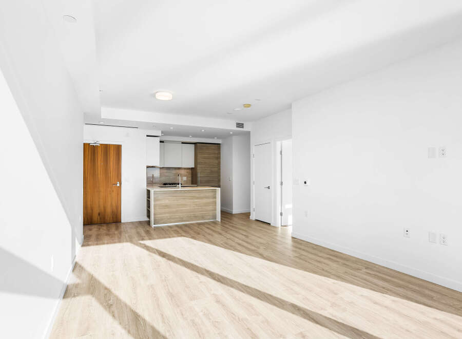 Step into this bright and airy open-concept living space, featuring a modern kitchen with a sleek island and ample cabinet storage.