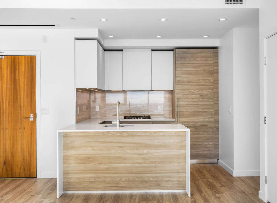 Experience modern living in this stunning kitchen featuring sleek white cabinetry and warm wood accents.
