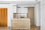 Experience modern living in this stunning kitchen featuring sleek white cabinetry and warm wood accents.