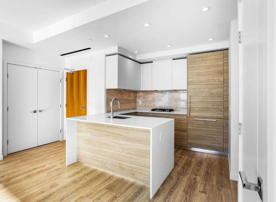 Experience modern living in this stunning kitchen featuring sleek white cabinetry and warm wood accents.