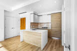 Experience modern living in this stunning kitchen featuring sleek white cabinetry and warm wood accents.