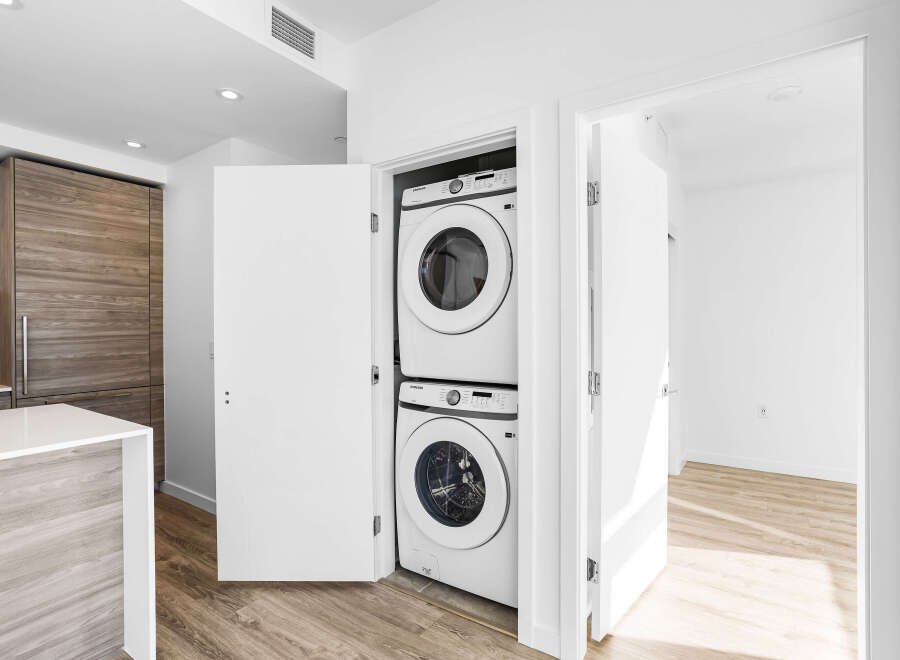Discover modern convenience with this stacked Samsung washer and dryer set, neatly tucked away in a dedicated closet.