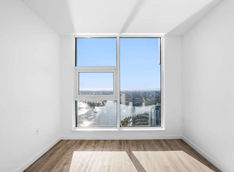 Experience breathtaking panoramic views from this stunning apartment, featuring expansive windows that showcase a vibrant cityscape and glistening waterfront.