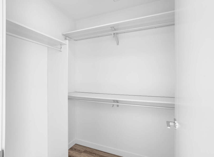 Step into this spacious walk-in closet, featuring ample shelving and a sturdy hanging rod, perfect for organizing your wardrobe.