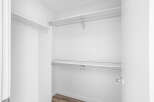 Step into this spacious walk-in closet, featuring ample shelving and a sturdy hanging rod, perfect for organizing your wardrobe.