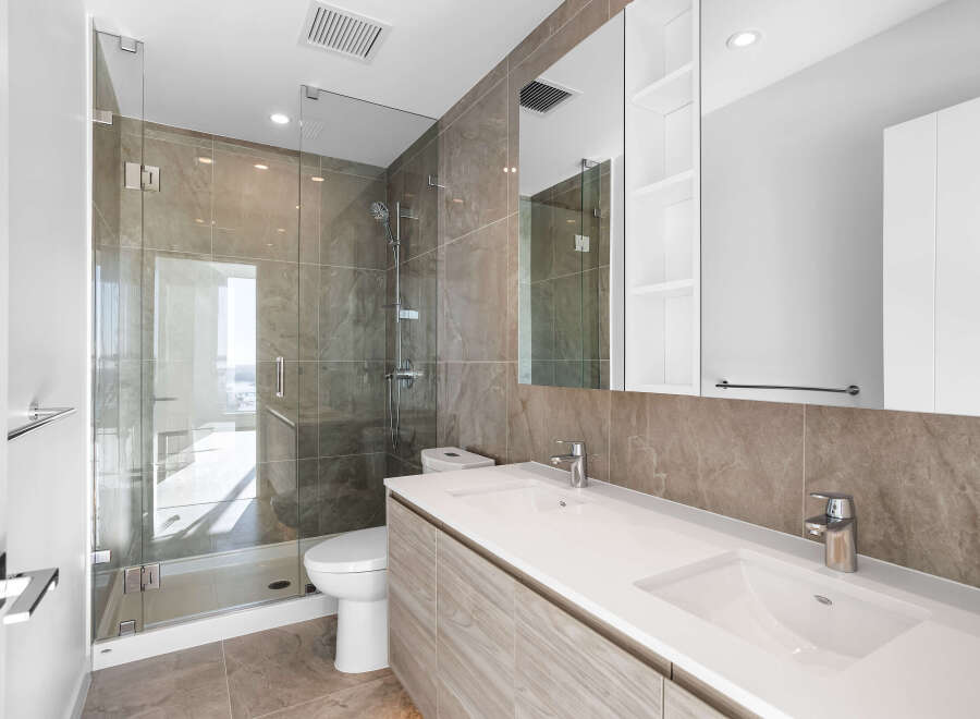 Experience modern luxury in this stunning bathroom, featuring a spacious glass-enclosed shower with elegant marble tilework.