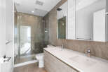 Experience modern luxury in this stunning bathroom, featuring a spacious glass-enclosed shower with elegant marble tilework.