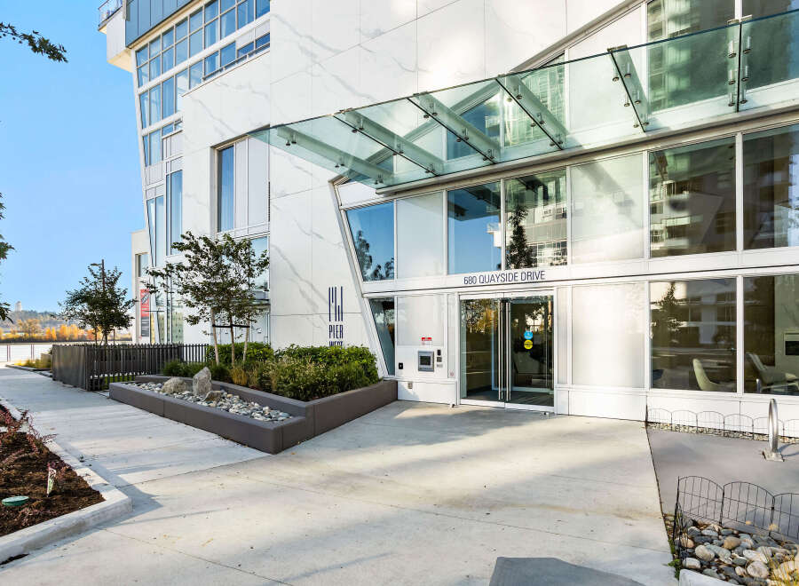 Experience modern living at 680 Quayside Drive, a stunning property featuring a sleek white marble facade and expansive glass windows.