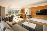 Experience modern living in this spacious open-plan apartment, featuring a dining area with stunning mountain views and a cozy living room with a contemporary fireplace.