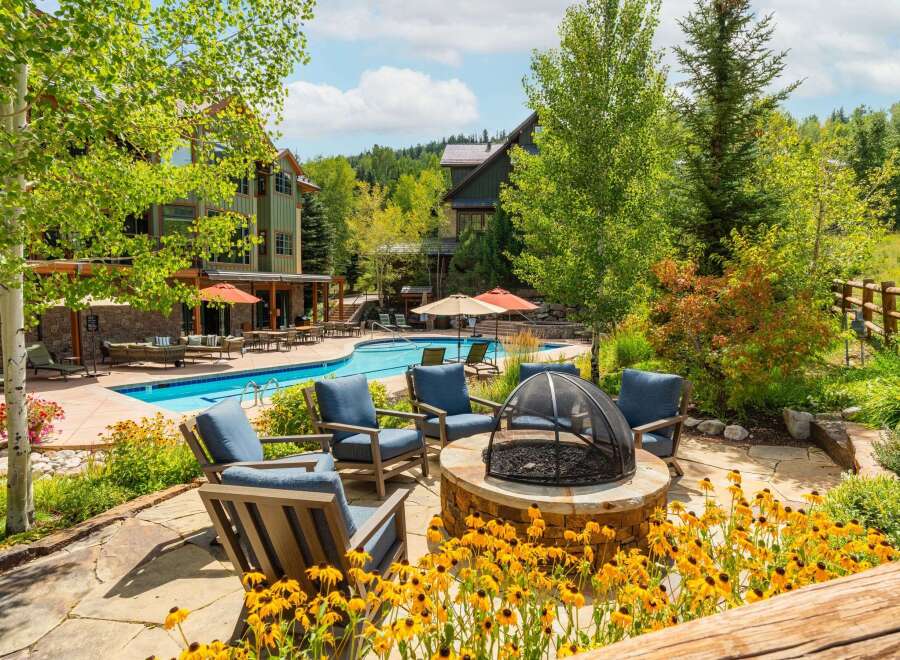 Enjoy the ultimate outdoor living experience with this stunning property featuring a sparkling swimming pool and a cozy fire pit area, perfect for relaxation and entertainment.