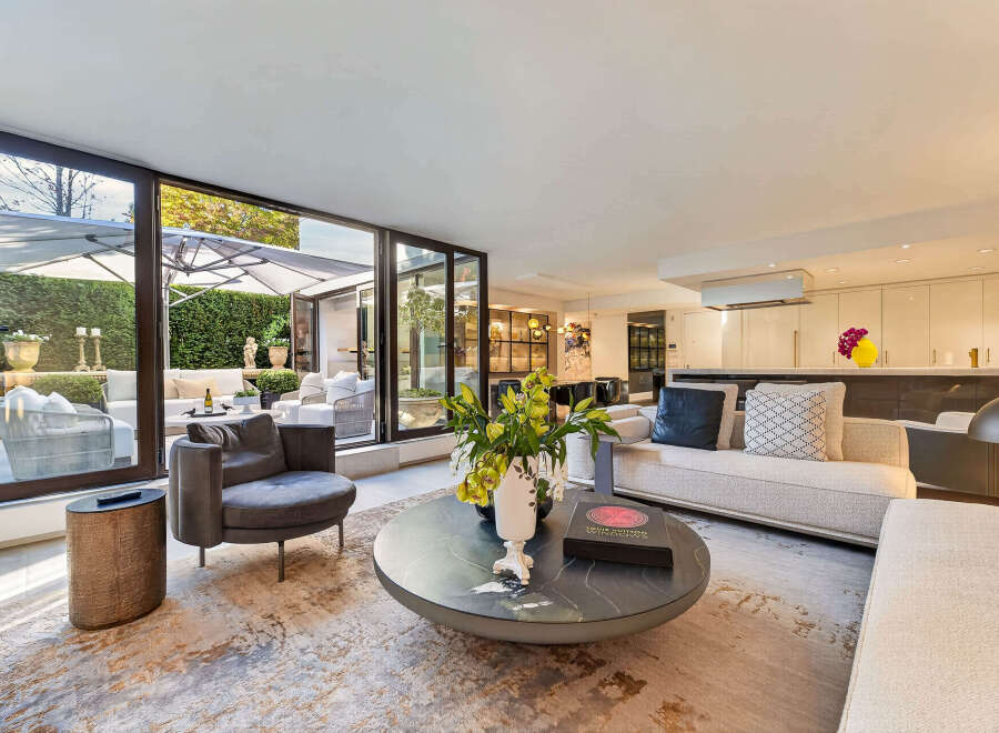 Experience luxurious indoor-outdoor living in this stunning modern residence, featuring expansive glass doors that seamlessly connect the elegant living space to a beautifully landscaped patio.
