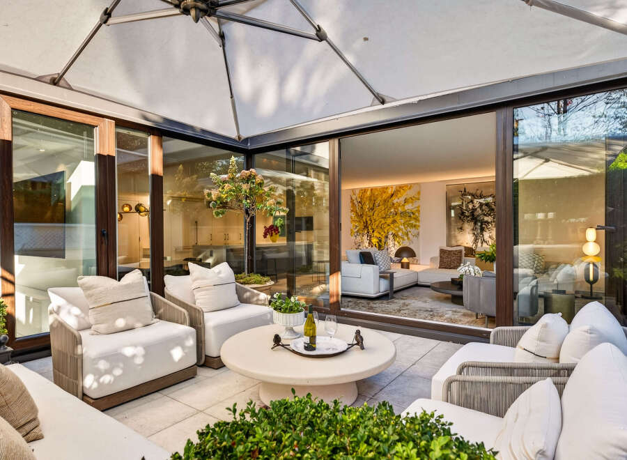 Experience luxurious indoor-outdoor living with this stunning patio featuring comfortable seating and a retractable awning.