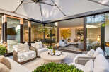 Experience luxurious indoor-outdoor living with this stunning patio featuring comfortable seating and a retractable awning.