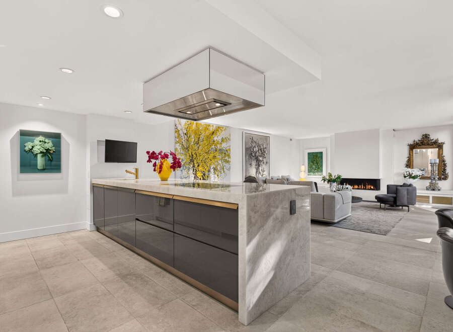 Experience luxury living in this stunning open-concept space, featuring a sleek modern kitchen with a marble island and a sophisticated living area.