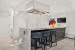 Experience luxury in this modern kitchen featuring sleek white cabinetry and a stunning marble island.