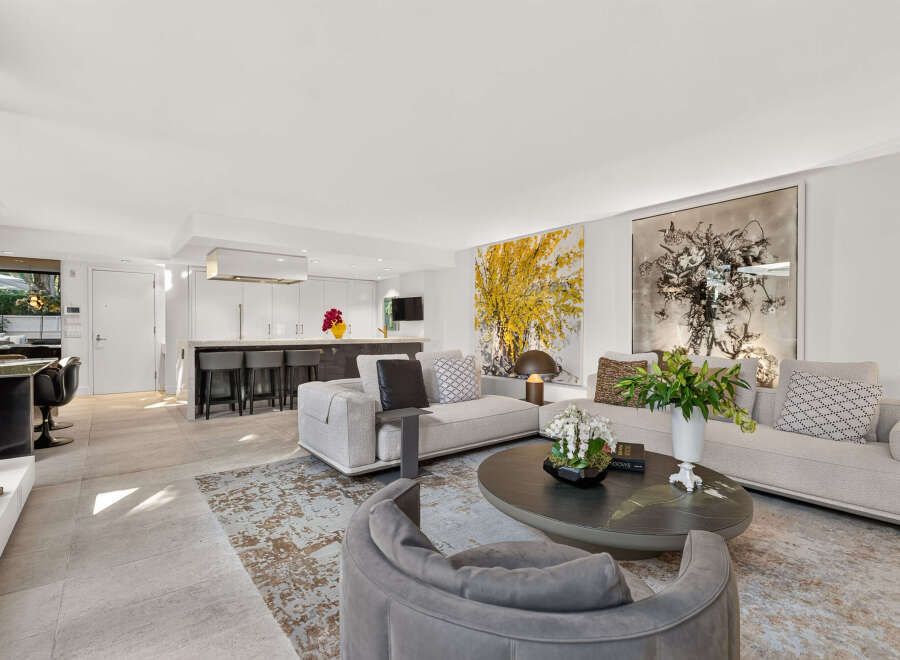 Experience modern luxury in this open-concept living space, featuring a sleek kitchen with a waterfall island and bar seating.