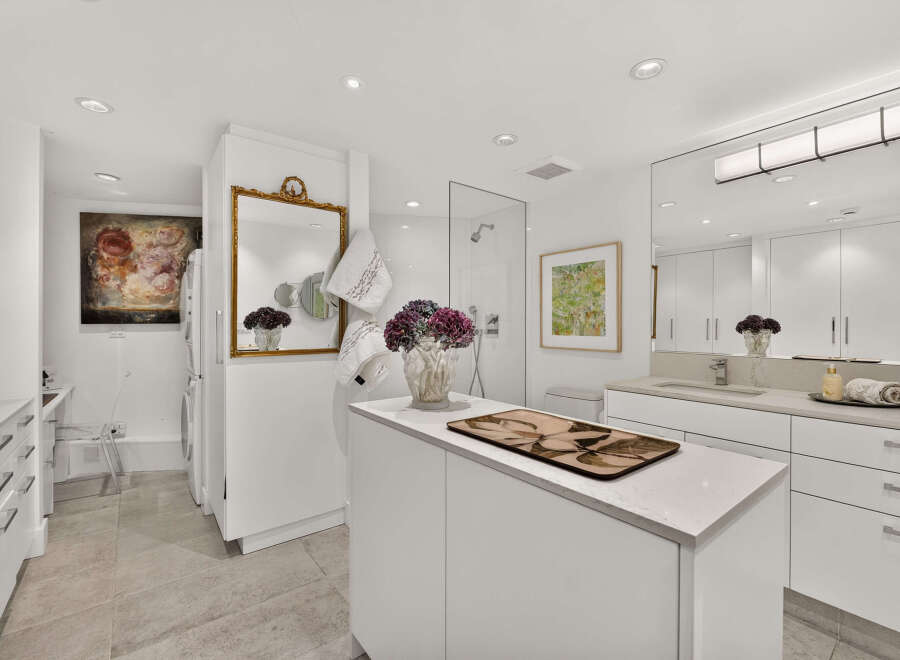 This luxurious bathroom boasts a spacious walk-in shower with a glass enclosure and a modern showerhead.