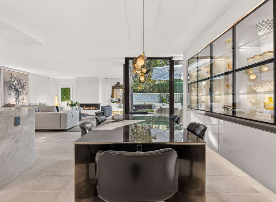 Experience luxury living in this stunning open-plan residence, featuring a sleek dining area with a modern table and chairs, perfect for entertaining.