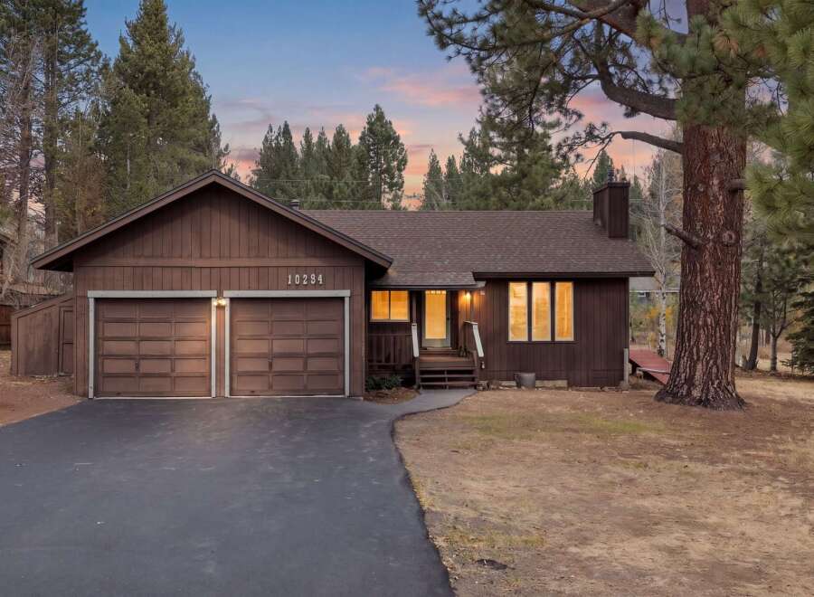 Nestled amidst tall pine trees, this charming brown home offers a serene retreat.