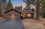 Nestled amidst tall pine trees, this charming brown home offers a serene retreat.