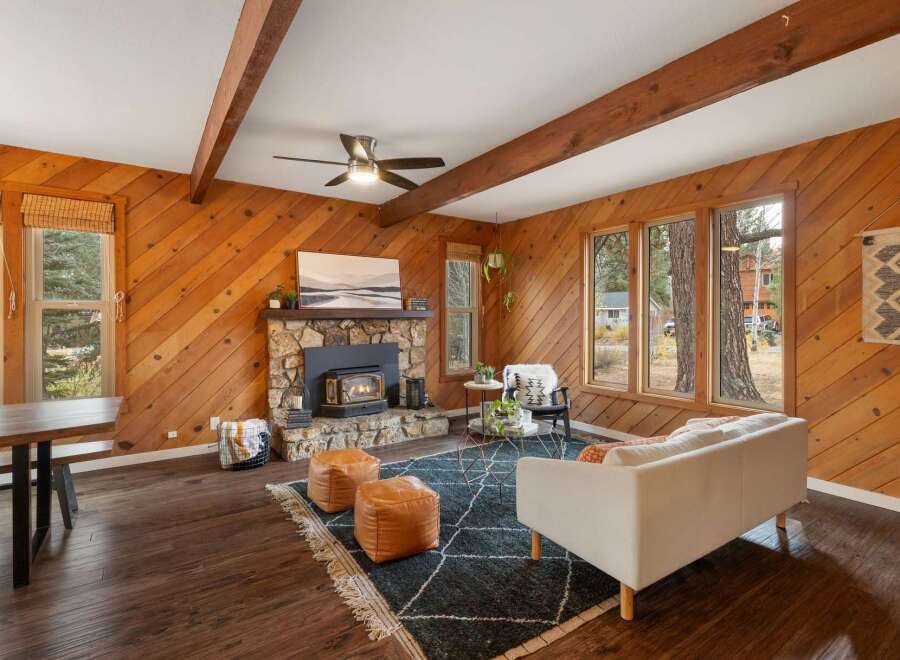 Experience cozy living in this rustic living room featuring a stone fireplace with a wood-burning insert, perfect for chilly evenings.