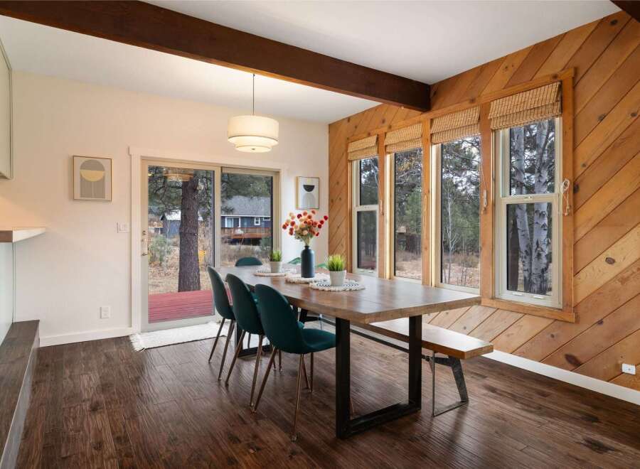 This dining room features a rustic charm with its warm wood-paneled walls and exposed wooden beams.