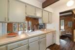 This charming kitchen boasts a spacious farmhouse sink and a butcher block countertop, perfect for meal preparation.