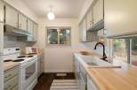This charming kitchen boasts light sage green cabinetry complemented by warm butcher block countertops.