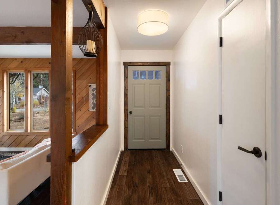 Step into a welcoming entryway featuring rustic wood beams and paneling, creating a warm and inviting atmosphere.