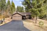 Nestled among mature pine trees, this charming brown home offers a serene retreat.