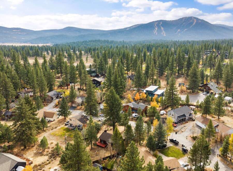 Discover this charming mountain home nestled amongst tall pine trees, offering a serene and private retreat.