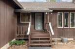 Welcome to this charming home featuring a welcoming front porch with a light blue door, perfect for greeting guests.