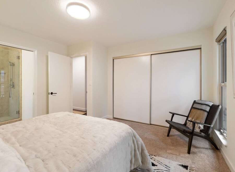 This bedroom offers a luxurious en-suite bathroom with a glass-enclosed shower, perfect for unwinding after a long day.