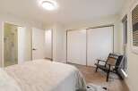 This bedroom offers a luxurious en-suite bathroom with a glass-enclosed shower, perfect for unwinding after a long day.