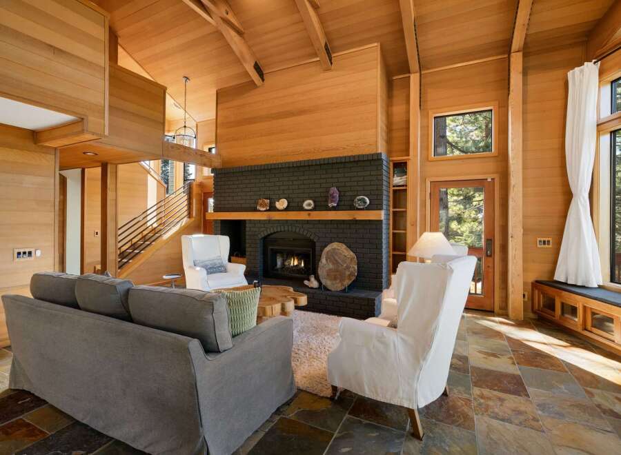 Experience rustic elegance in this stunning living room, featuring a grand dark brick fireplace as the focal point.