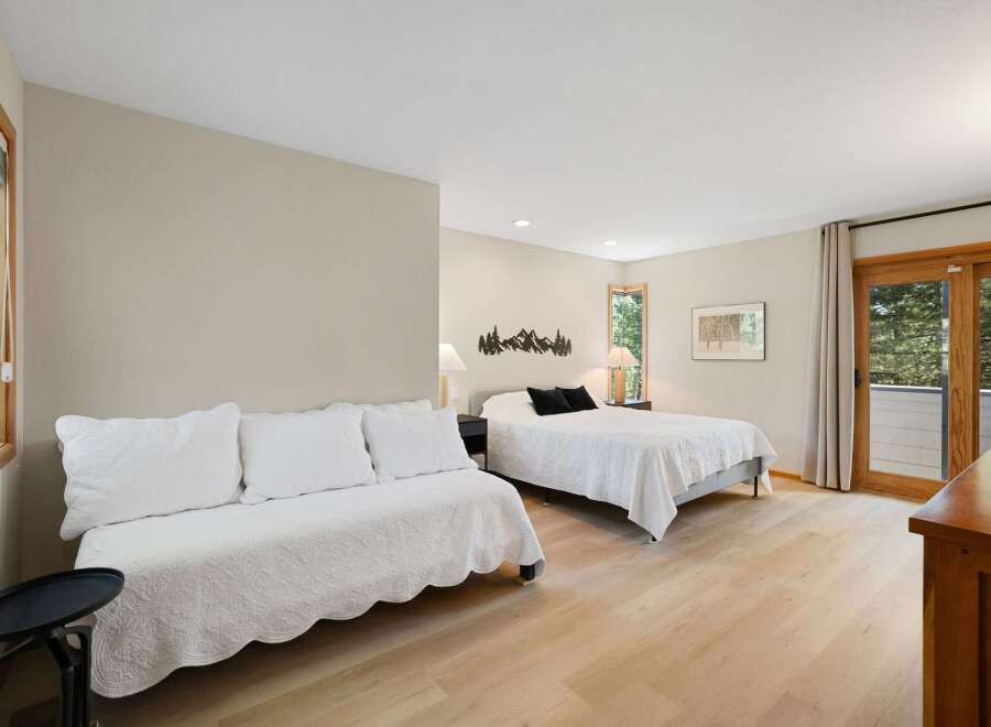This spacious bedroom offers a comfortable sleeping arrangement with a queen-size bed and a daybed, perfect for families or groups.