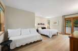 This spacious bedroom offers a comfortable sleeping arrangement with a queen-size bed and a daybed, perfect for families or groups.