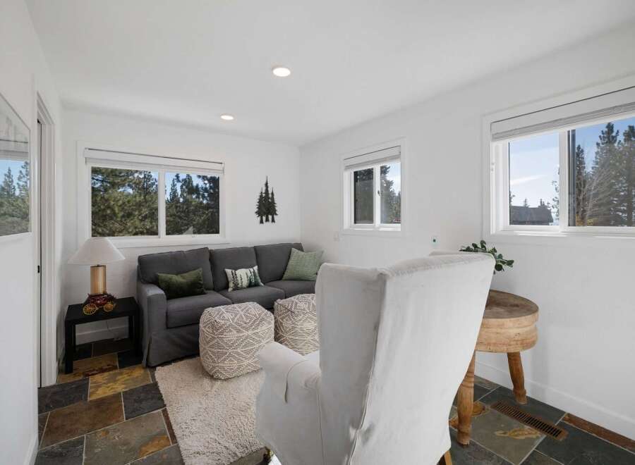This cozy living room features a comfortable gray sectional sofa adorned with green and patterned throw pillows, perfect for relaxing.