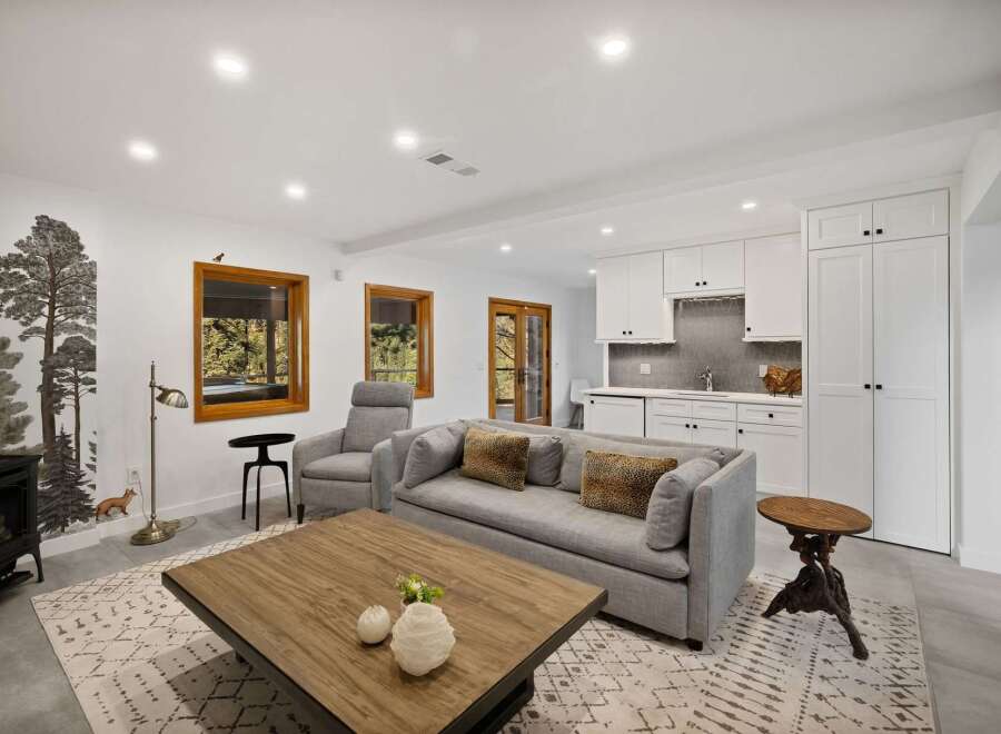 This modern living room features a cozy fireplace and a large grey sofa adorned with leopard print pillows, creating a warm and inviting atmosphere.