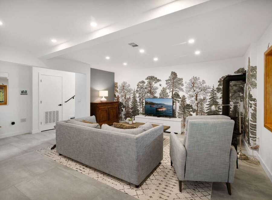 Step into this inviting living room, featuring a striking forest-themed mural that brings the outdoors in.