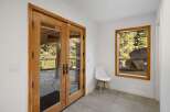 Step outside through elegant double wooden doors to a stone patio, offering a serene connection with the surrounding nature.