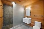 Experience a spa-like retreat in this modern bathroom, featuring a unique pebble-tiled shower and a sleek floating vanity.