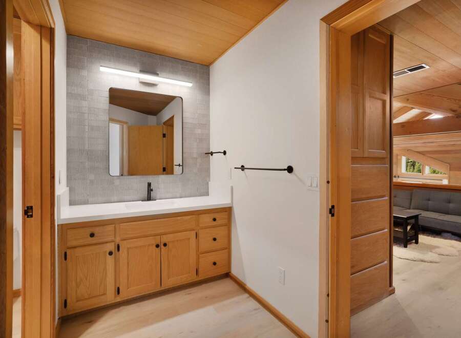 This modern bathroom features a sleek vanity with ample storage and a minimalist black faucet.
